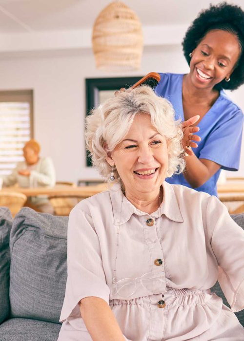 nurse-brush-hair-of-happy-mature-woman-in-the-livi-JAQXGJS.jpg